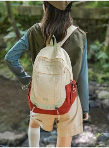 Detail shot of forest style casual outdoor sports backpack in beige and red color block design.