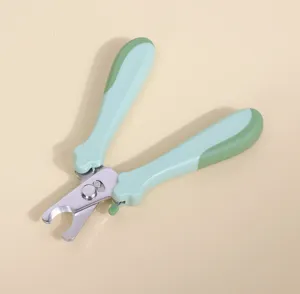 Close-up detail of the stainless steel pet nail clipper with ergonomic green non-slip handle.
