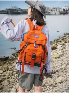 Detailansicht des orangefarbenen Outdoor-Rucksacks mit großer Kapazität und Wanderstockhalter.