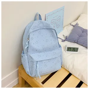 Détail de sac à dos d'école mignon bleu clair imprimé de cœurs, sac de toile décontracté.