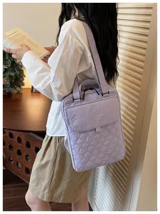 Dettaglio di una borsa shopper in nylon trapuntato viola chiaro indossata da una modella.