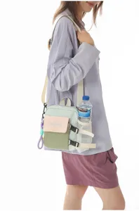 Vue détaillée du sac bandoulière color-block porté par le modèle avec poche filet latérale.