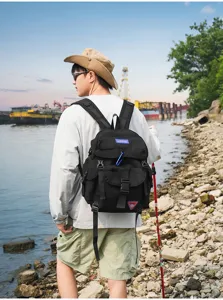 Detaillierte Außenansicht des praktischen schwarzen Rucksacks am Model am Flussufer.