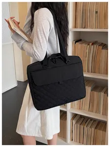 Vista dettagliata di una borsa tote in nylon trapuntato nero indossata da una modella in libreria.