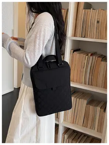 Vista dettagliata della borsa tote imbottita in nylon nero vicino alla libreria, stile chic