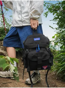 Detailansicht eines schwarzen Outdoor-Rucksacks mit strapazierfähigem Stoff und vielen Fächern.