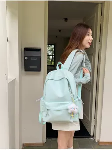 Vista dettagliata di uno zaino casual in nylon verde menta con grazioso ciondolo a nuvola.