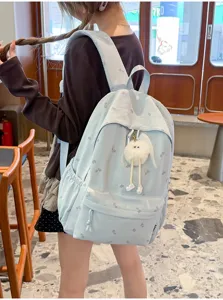 Süßer hellblauer Rucksack mit Blatt-Print und flauschigem Anhänger, stylische Schultasche.
