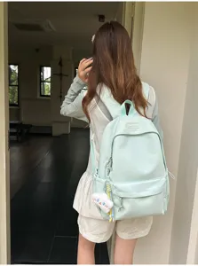 Dettaglio dello zaino casual verde chiaro con grande capacità e un simpatico ciondolo a nuvola.