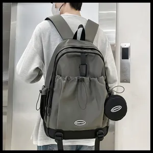 Vue détaillée d'un sac à dos gris plissé tendance avec petite pochette ronde et grand espace.