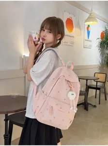 Süsser rosa Studentenrucksack Detail mit Ginkgoblatt-Muster und niedlichem Plüsch-Anhänger.