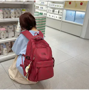 Detail view of the stylish red school backpack featuring cute star prints and large capacity storage.