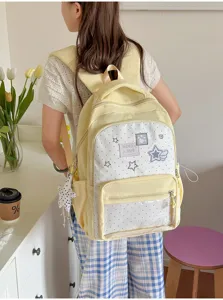 Nahaufnahme des gelben Polka-Dot-Rucksacks mit transparenter Fronttasche und Sternaufnähern.