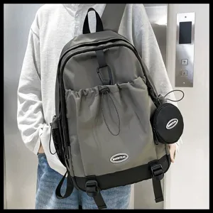 Vue détaillée du sac à dos gris tendance avec cordon de serrage et pochette latérale.