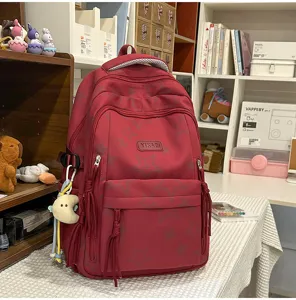 Details of red star print school backpack, large capacity casual daypack with cute pendants.