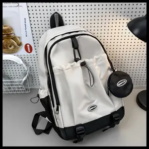 Gros plan sur les détails du sac à dos blanc et noir tendance avec sa poche avant et sa trousse.