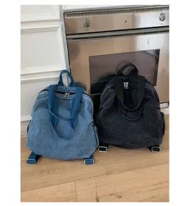 Vue détaillée des sacs à dos en denim lavé vintage avec poignées robustes, zips et couleurs.
