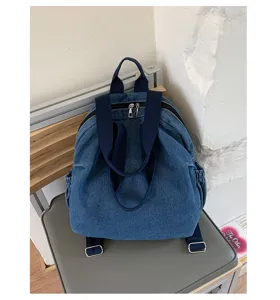 Vue détaillée d'un sac à dos en denim bleu lavé rétro avec des bretelles confortables et zips.