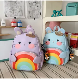 Cute cartoon rainbow children schoolbag detail view, colorful animal ears design with bear charm.
