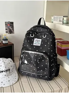 Vista dettagliata dello zaino ita a pois neri con tasca trasparente in un ambiente accogliente.