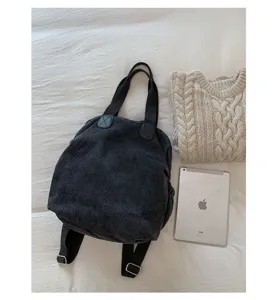 Sac à dos en toile lavée rétro vue à plat avec pull et tablette accessoire du quotidien.