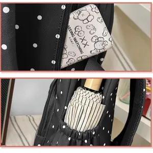 Vista dettagliata dello zaino a pois neri con tasche pratiche e grazioso design per studenti.