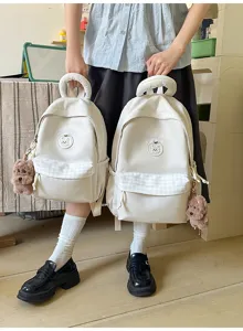 Niedlicher beiger Schülerrucksack mit Karotasche, süßer Bärenstickerei und Plüschhundanhänger.