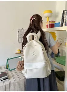 Süßer Canvas-Schulranzen für Schüler mit karierter Vordertasche und Bärchen-Stickerei.