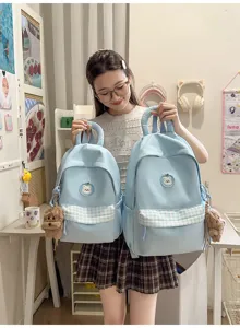 Detailansicht des süßen blauen Schülerrucksacks mit Karentasche und Bärenanhänger.