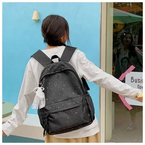 Vue lifestyle détaillée d'un sac à dos noir imprimé de cœurs porté par une personne.