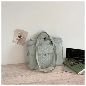 Borsa tote per laptop in nylon trapuntato verde chiaro dettaglio, scena di stile di vita casual.