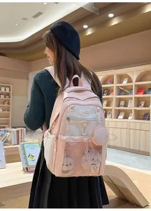 Détail de sac à dos scolaire rose en toile avec une poche en filet et de belles peluches.