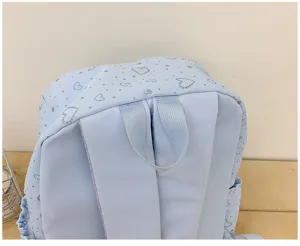 Sac à dos d'écolier bleu clair avec imprimé cœur scintillant mignon, vue rapprochée des détails.
