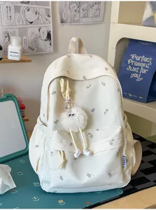 Detailaufnahme des süßen rucksack mit blätterdruck und plüschanhänger für mädchen schülerinnen.