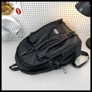 Vue détaillée du sac à dos noir en nylon avec plis, grande capacité et boucles.