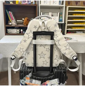 Detail view of the cute star print college style lightweight backpack placed on suitcase.