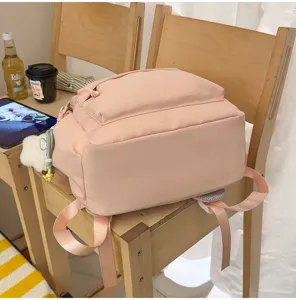 Vista dettagliata dello zaino scolastico rosa in nylon di grande capacità per studenti.