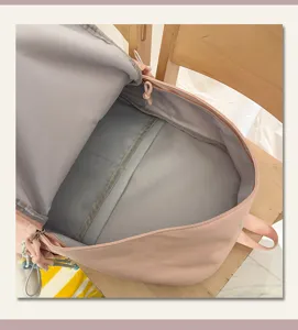 Dettaglio zaino scolastico in nylon rosa che mostra ampio scomparto interno e design con cerniera.