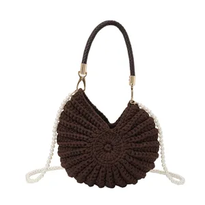 Vue détaillée du sac à main en tricot marron en forme de coquillage avec perles.
