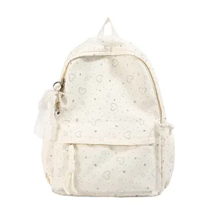 Vue détaillée d'un joli sac à dos blanc de style japonais avec cœurs argentés et perles.