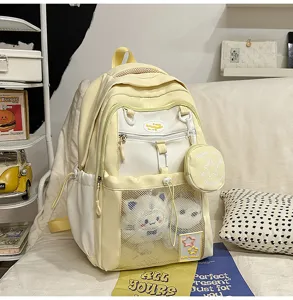 Vue détaillée du joli sac à dos d'école bicolore avec poche avant en filet et peluche.