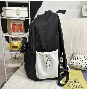 Sac à dos d'école pour étudiant contrasté noir et blanc vue latérale poches.