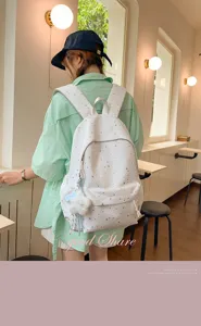 Detailaufnahme des süßen Schulrucksacks mit Sternenmuster und einem schönen Plüschtier-Anhänger.