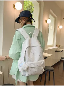 Detailansicht des stilvollen weißen Rucksacks mit Sternenmuster im Lifestyle-Szenenbild.