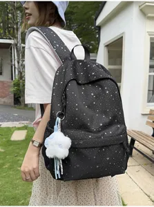 Detailansicht des schwarzen Rucksacks mit Sternenmuster, grossem Fach und weichem Plüschanhänger.