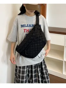 Detailaufnahme einer Person mit einer stylischen, schwarz karierten Freizeittasche aus Nylon.