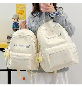 Detailaufnahme des süßen japanischen Polka-Dot-Schülerrucksacks mit Stickerei und Anhänger.