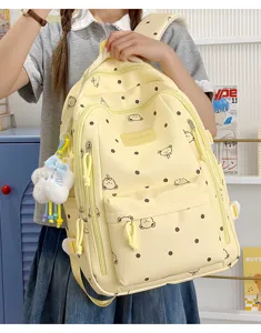 Vista detallada de la bonita mochila amarilla de lunares con estampado de oso y peluche.