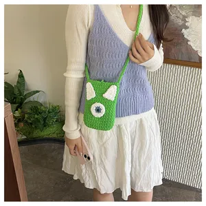Handcrafted knitted cartoon phone bag detail, cute green crossbody bag for travel and commuting.