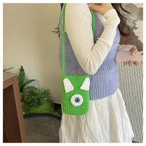 Green knitted crochet crossbody phone bag with cute single-eyed monster design for daily use.
